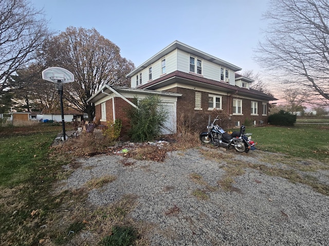 property exterior at dusk with a garage and a yard