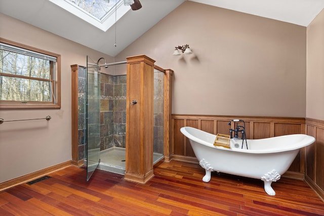 bathroom with vaulted ceiling with skylight, shower with separate bathtub, and wood-type flooring