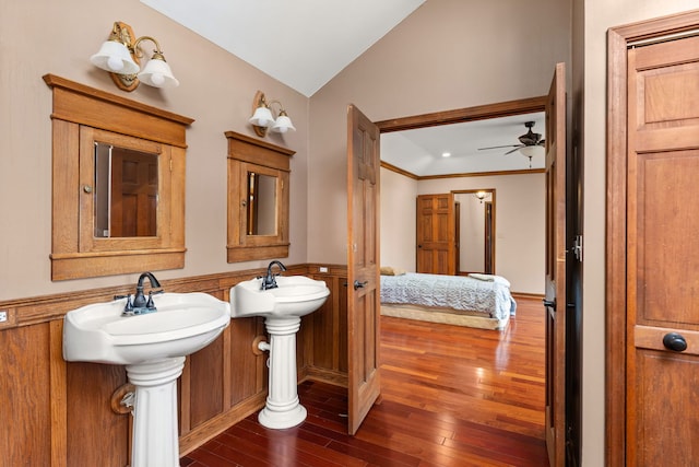 bathroom with ornamental molding, vaulted ceiling, dual sinks, ceiling fan, and wood-type flooring