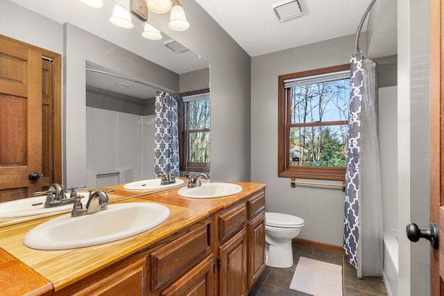 full bathroom featuring vanity, shower / bath combo, toilet, and tile patterned floors