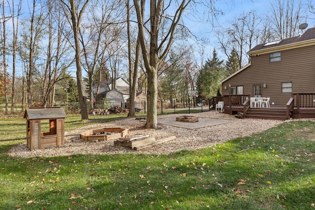 view of yard with a deck and a fire pit