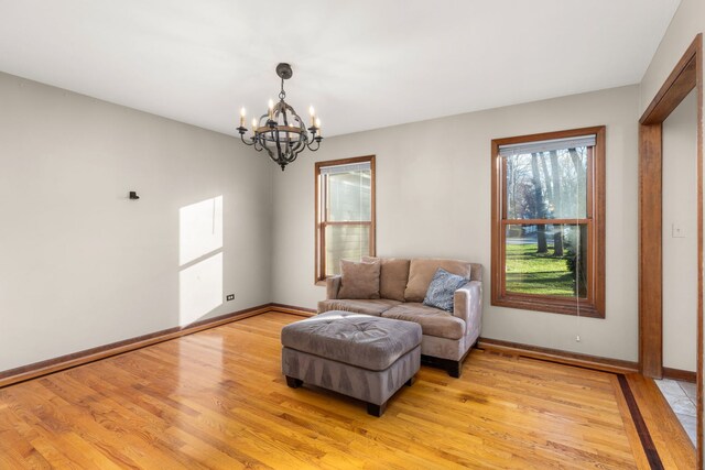 sitting room with sink, plenty of natural light, a notable chandelier, and light wood-type flooring