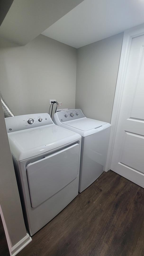 washroom with dark hardwood / wood-style flooring and washer and clothes dryer