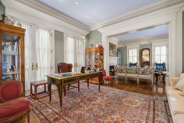 sitting room with dark wood-type flooring, a healthy amount of sunlight, and crown molding