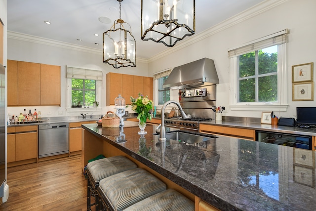 kitchen featuring plenty of natural light, pendant lighting, a kitchen breakfast bar, dishwasher, and wall chimney exhaust hood