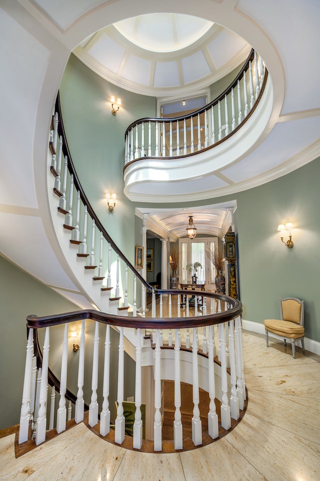 stairs with a high ceiling and crown molding