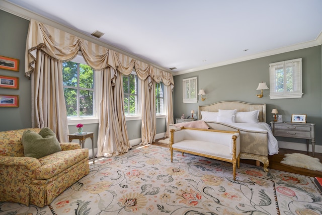 bedroom with ornamental molding and light wood-type flooring