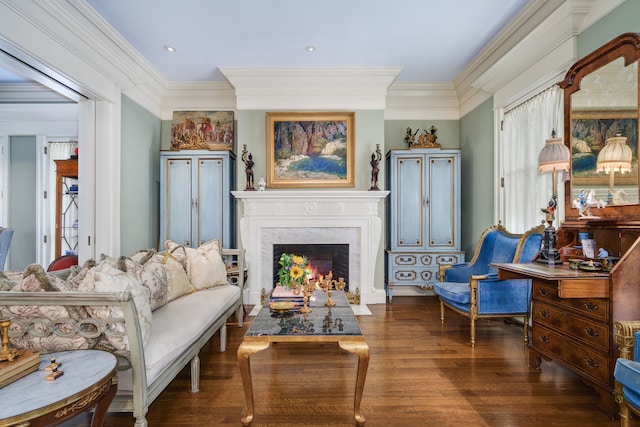 sitting room featuring dark wood-type flooring, ornamental molding, and a premium fireplace