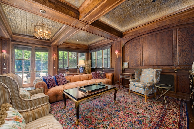 living room featuring ornamental molding, plenty of natural light, and beamed ceiling