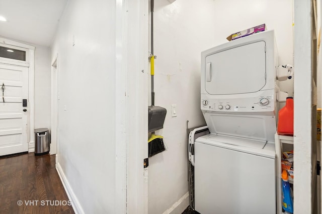 washroom featuring stacked washer and dryer and dark wood-type flooring