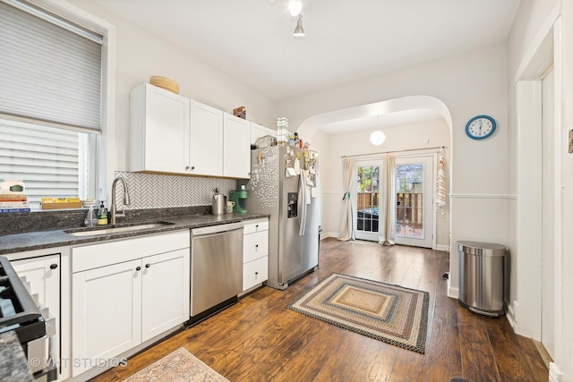 kitchen featuring dark hardwood / wood-style flooring, tasteful backsplash, stainless steel appliances, sink, and white cabinetry