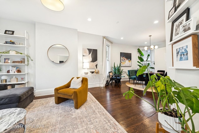 living room with a notable chandelier and dark wood-type flooring