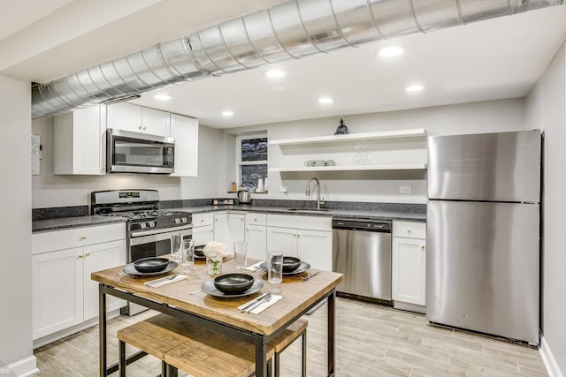 kitchen featuring sink, white cabinetry, stainless steel appliances, and light hardwood / wood-style flooring