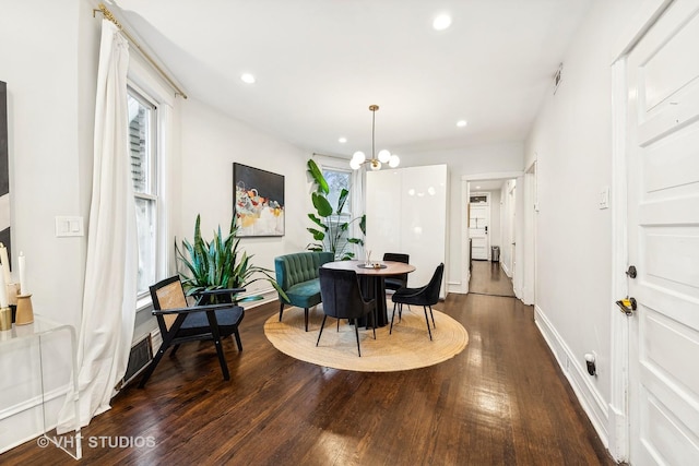 dining area featuring a notable chandelier and dark hardwood / wood-style flooring