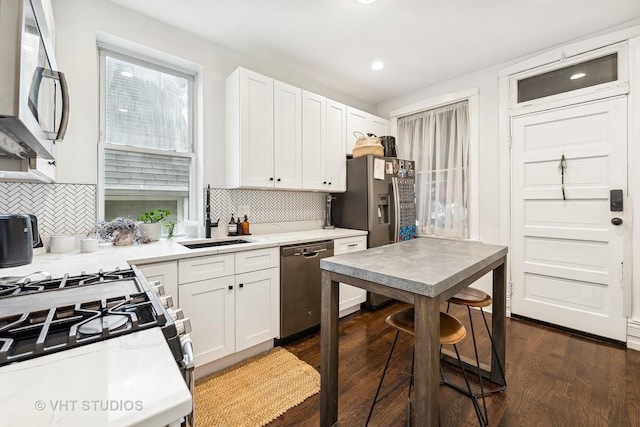 kitchen with dark hardwood / wood-style floors, sink, white cabinetry, and stainless steel appliances