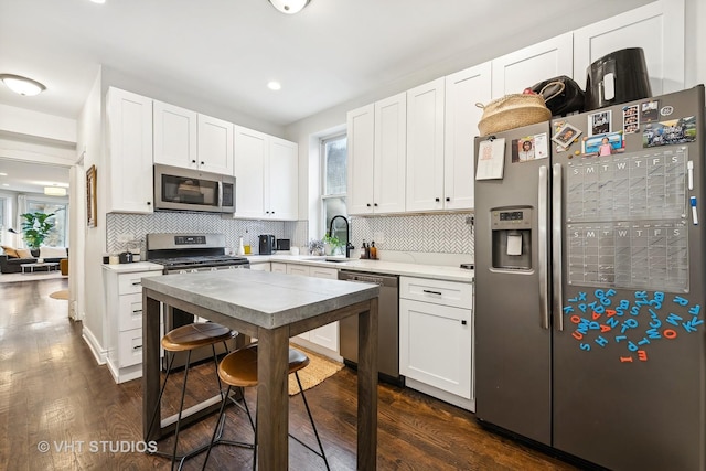 kitchen with white cabinets, stainless steel appliances, dark hardwood / wood-style floors, and sink