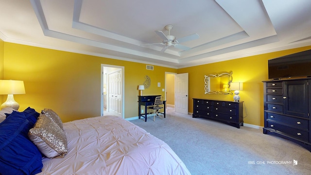 bedroom featuring a tray ceiling, light colored carpet, and ceiling fan