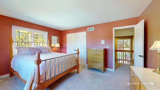 bedroom featuring light colored carpet and a closet