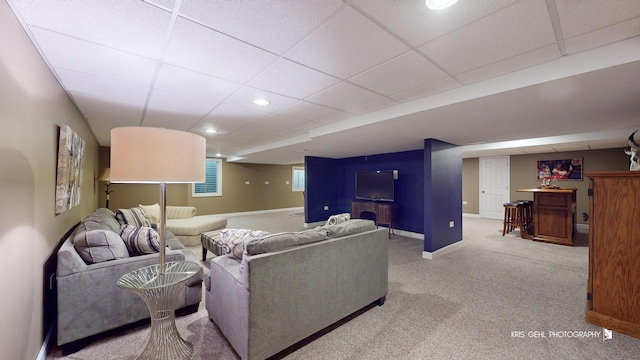 living room featuring light carpet and a drop ceiling