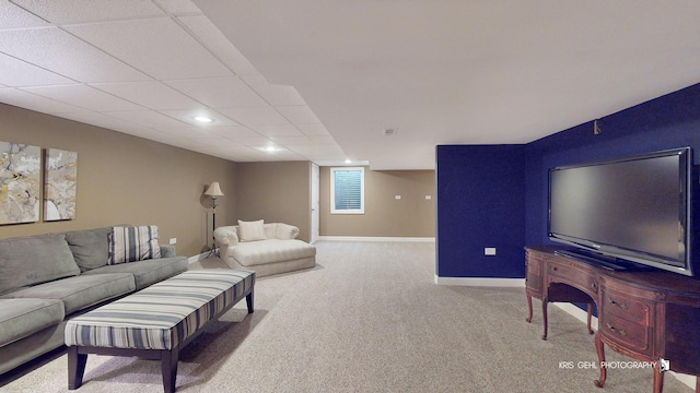 living room featuring a paneled ceiling and carpet