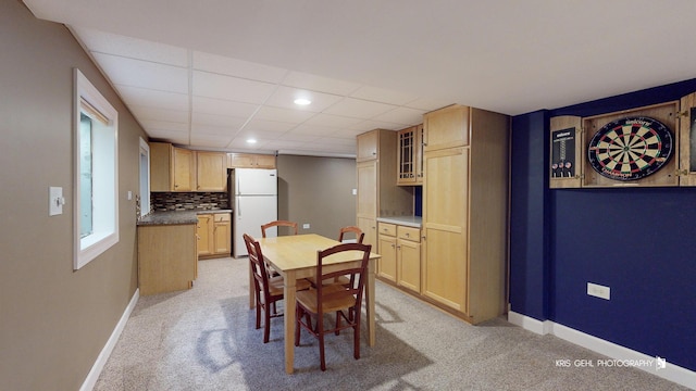 dining room featuring light carpet and a drop ceiling