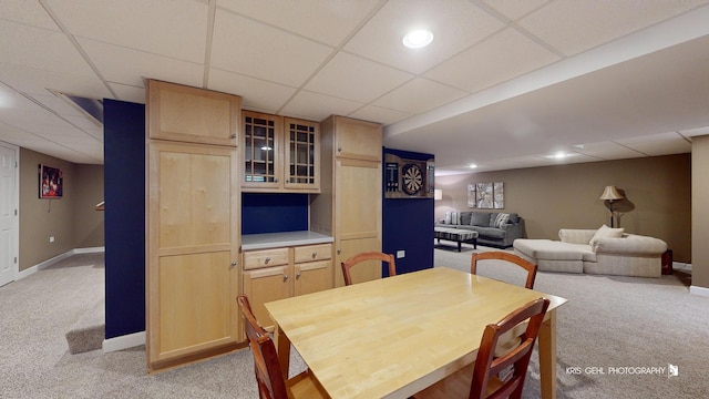 carpeted dining space with a drop ceiling