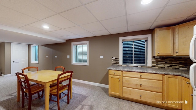 dining space featuring light carpet and a paneled ceiling