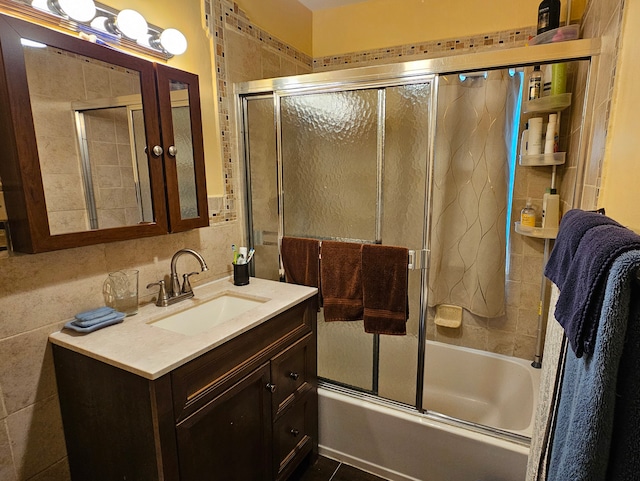 bathroom with vanity, bath / shower combo with glass door, tile patterned flooring, and tile walls