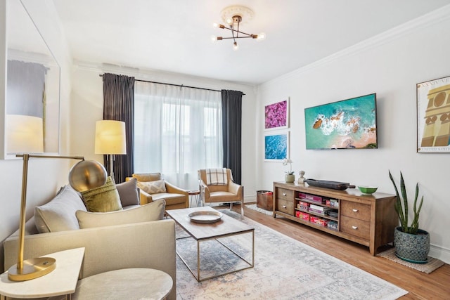 living room with ornamental molding, an inviting chandelier, and wood-type flooring