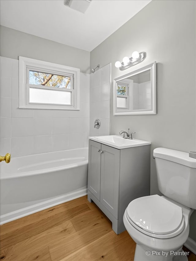 full bathroom featuring toilet, vanity, tiled shower / bath combo, and hardwood / wood-style flooring