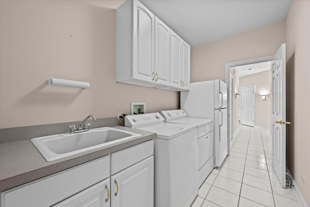 laundry area featuring washer and clothes dryer, cabinets, light tile patterned floors, and sink