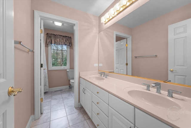 bathroom with tile patterned flooring, vanity, and toilet