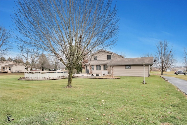 view of front of property featuring a front lawn and a covered pool