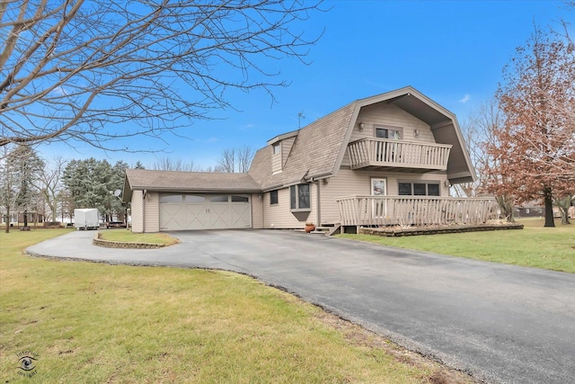 front facade featuring a balcony, a front lawn, and a garage