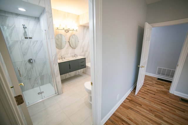 bathroom featuring hardwood / wood-style flooring, vanity, toilet, and a shower with shower door