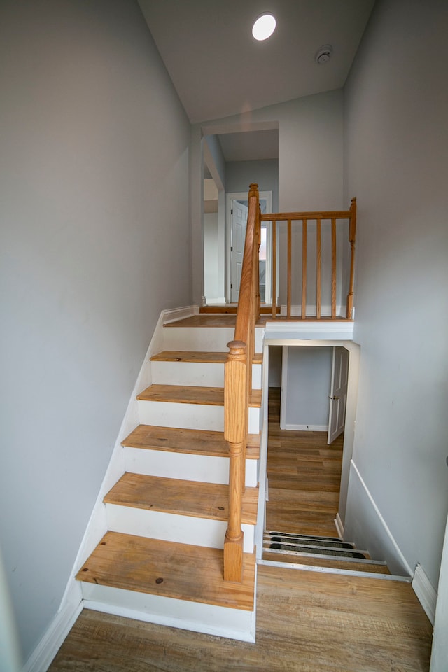 stairway with hardwood / wood-style floors