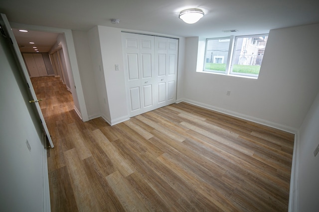 unfurnished bedroom featuring light hardwood / wood-style flooring and a closet