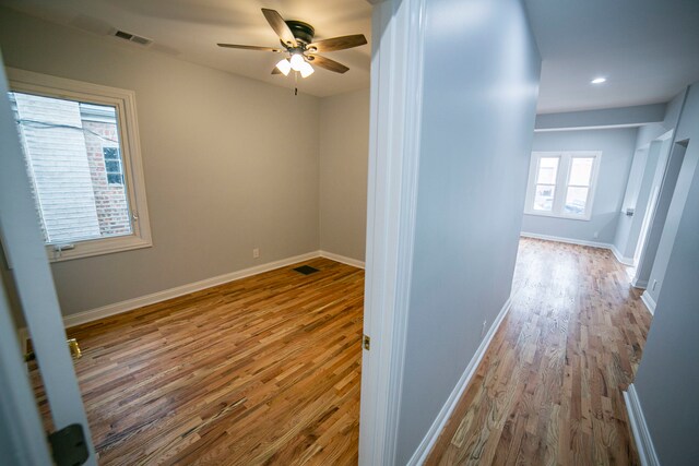 corridor with light wood-type flooring and a healthy amount of sunlight