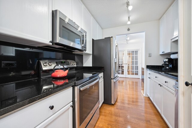 kitchen featuring white cabinetry, stainless steel appliances, and light hardwood / wood-style flooring