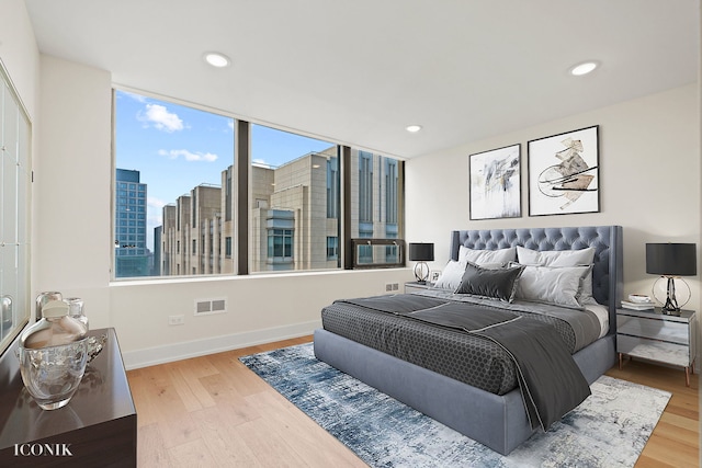 bedroom with wood finished floors, baseboards, visible vents, and recessed lighting