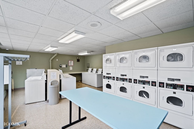 common laundry area featuring washer and dryer, stacked washing maching and dryer, baseboards, and light floors
