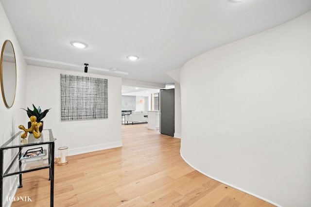 corridor featuring recessed lighting, light wood-style flooring, and baseboards