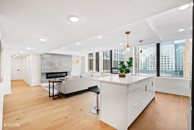 kitchen featuring modern cabinets, light wood-type flooring, white cabinetry, a breakfast bar, and a center island