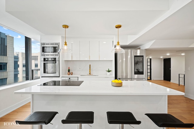 kitchen featuring light wood-style floors, white cabinetry, modern cabinets, and stainless steel appliances