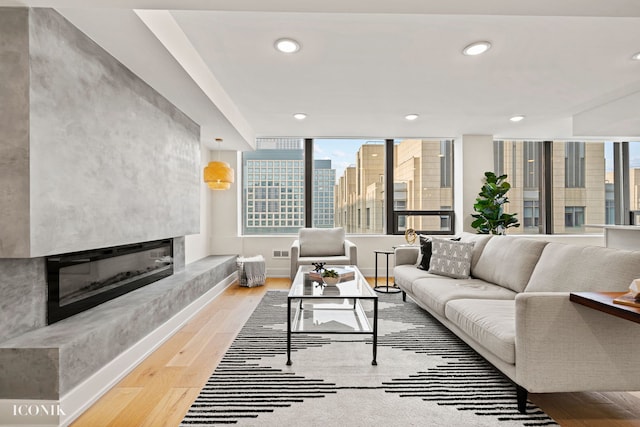 living area with visible vents, a high end fireplace, recessed lighting, wood finished floors, and a city view
