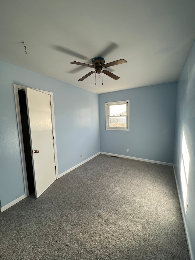 carpeted spare room with ceiling fan