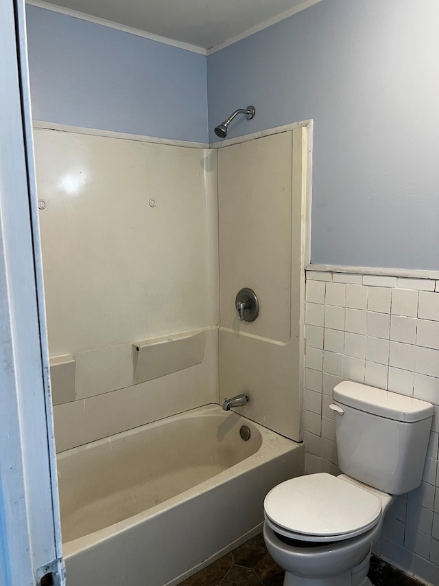 bathroom with toilet, tile walls, tile patterned floors, and shower / bathtub combination