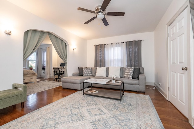 living room featuring ceiling fan and dark hardwood / wood-style flooring