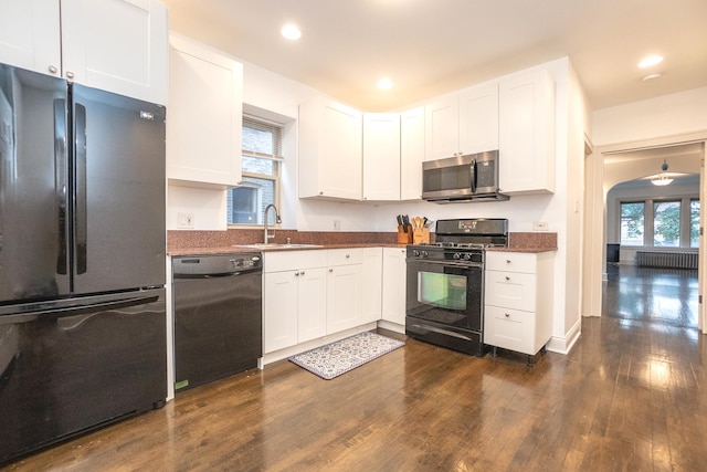 kitchen featuring sink, dark wood-type flooring, black appliances, and white cabinetry