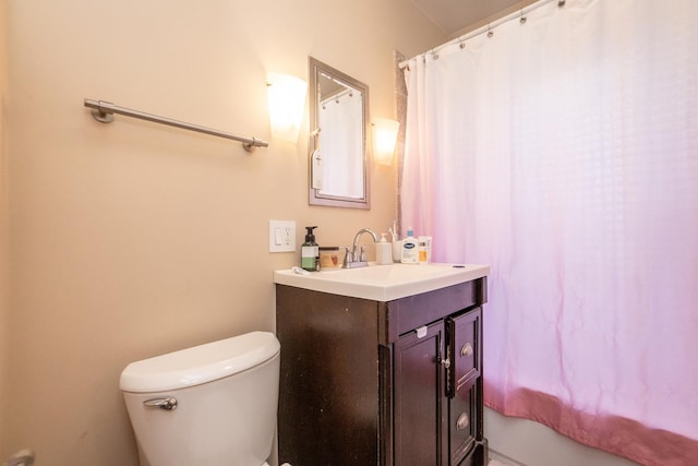 bathroom featuring toilet, curtained shower, and vanity